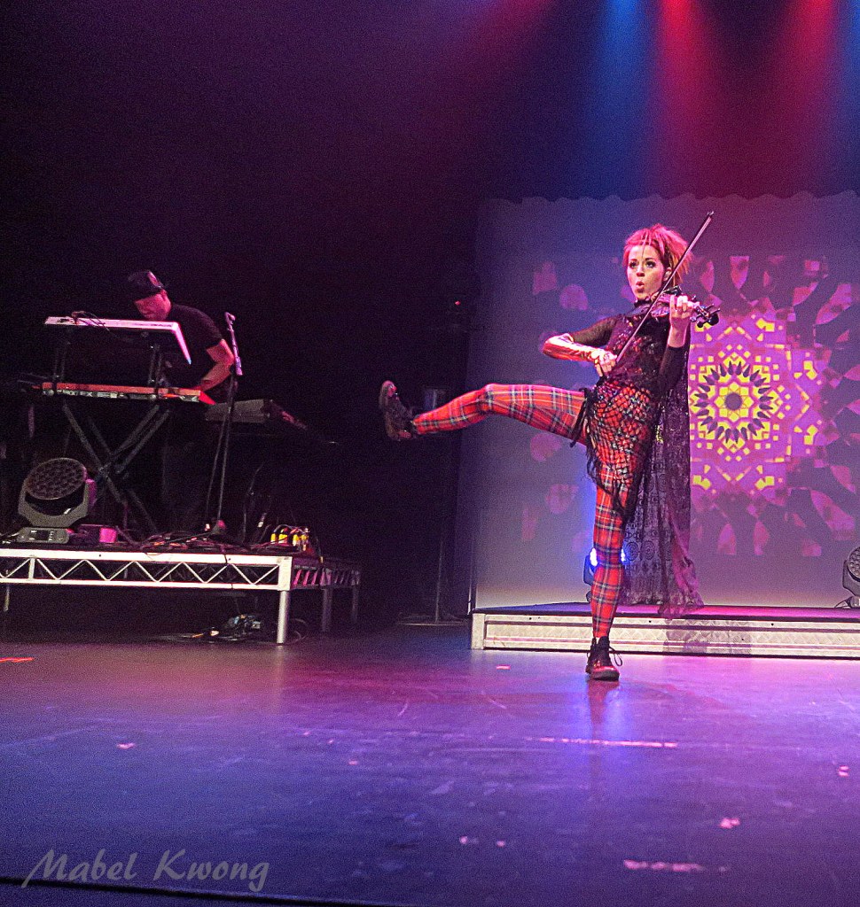 Electric Daisy Violin. Balancing on one leg.